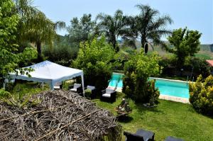 einen Garten mit einem Pool und einem weißen Zelt in der Unterkunft Villaggio Naif Girasole in Monterotondo
