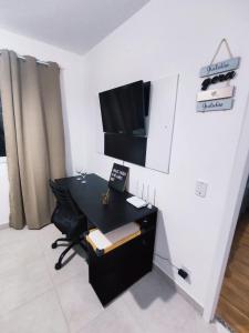 an office with a desk and a tv on a wall at Flat Metrô Giovanni Gronchi - Expo Transamérica - Vibra São Paulo - Autódromo in Sao Paulo