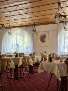 a dining room with tables and chairs and a window at Hotel Acla Filli in Zernez