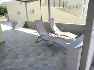 dwa krzesła siedzące na dachu budynku w obiekcie Apartmani Verica w mieście Karlobag