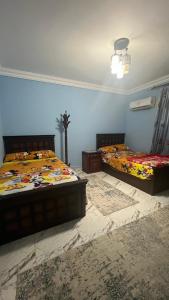 two twin beds in a room with blue walls at شقه للايجار بمدينه نصر in Cairo