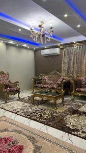 a living room with two couches and a chandelier at شقه للايجار بمدينه نصر in Cairo