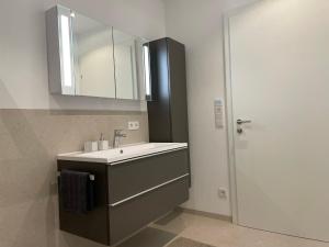 a bathroom with a sink and a mirror at EXCLUSIVES APARTMENT - Auszeit Mondsee in Mondsee