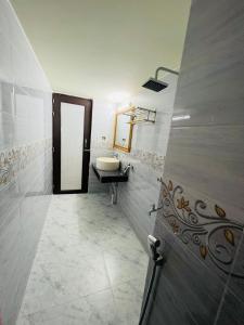 een badkamer met een wastafel en een spiegel bij HOTEL BLUE BIRD in Dhaka