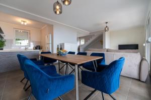 kuchnia i salon z drewnianym stołem i niebieskimi krzesłami w obiekcie Villas Monte Hill w Budvie