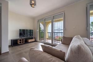 ein Wohnzimmer mit einem Sofa und einem TV in der Unterkunft Villas Monte Hill in Budva