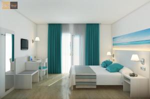 a bedroom with a white bed with blue pillows at Hotel Playas de Paguera in Paguera