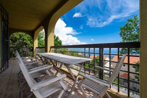 een veranda met een tafel en stoelen op een balkon bij Villas Monte Hill in Budva
