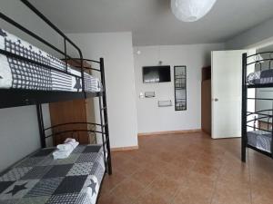 a room with two bunk beds and a tv at Demis Apartments in Sidari