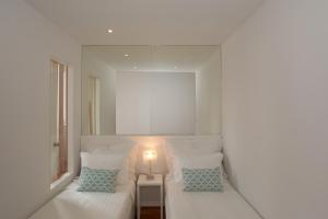 a bedroom with a white bed and white pillows at Bolhão Nobre Apartments in Porto