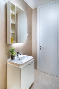 ein Badezimmer mit einem weißen Waschbecken und einem Spiegel in der Unterkunft Homa Luxury Apartments Tivat with seaview in Donja Lastva