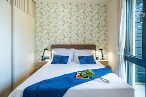 ein Schlafzimmer mit einem großen Bett mit blauer Bettwäsche und blauen Kissen in der Unterkunft Homa Luxury Apartments Tivat with seaview in Donja Lastva