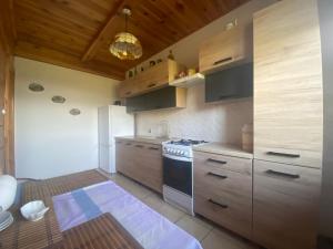 a kitchen with wooden cabinets and a stove at Ostoja nad Bugiem in Janów Podlaski