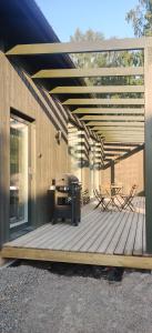 una terraza de madera con mesa y sillas. en New Villa w/sauna, jacuzzi &wifi, en Hämeenlinna