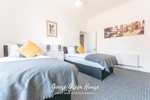 PembertonにあるGoose Green Contractor Accommodationの白い壁のベッドルーム(ベッド2台、黄色い枕付)