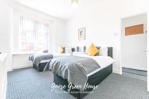 a white bedroom with two beds and a window at Goose Green Contractor Accommodation in Pemberton