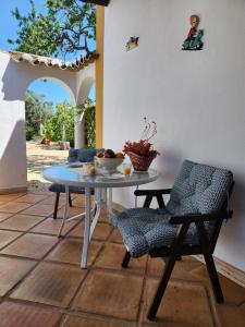 un patio avec une table et des chaises sur un patio dans l'établissement Quinta Das Amendoas, à Carvoeiro