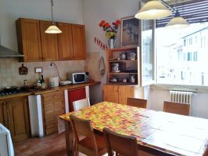 eine Küche mit einem Tisch und Stühlen sowie einem Tisch und einem Fenster in der Unterkunft Alla Porta di Baccio in Lastra a Signa