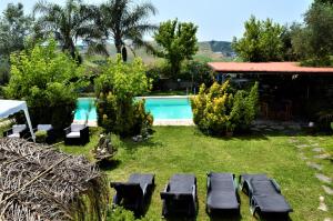 um quintal com uma piscina e uma casa em Villaggio Naif Mimosa em Monterotondo