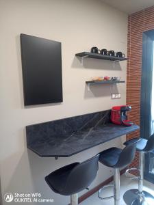 a desk with two chairs and a television on a wall at Suite XIMENA con piscina in Viveiro +19 photos