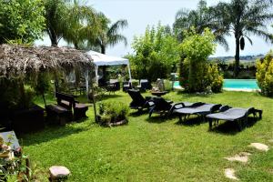 um quintal com cadeiras, uma mesa e uma piscina em Villaggio Naif Mimosa em Monterotondo