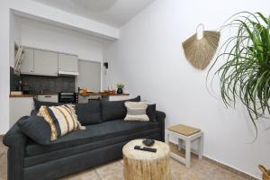 a living room with a black couch and a table at Rania Residence in Skopelos Town