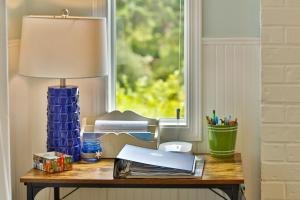 a table with a lamp and a desk with a window at Sandpiper Shores in Florence