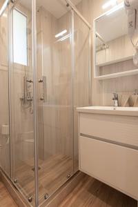 uma casa de banho com uma cabina de duche em vidro e um lavatório. em Bukovo Apartment em Oinófita