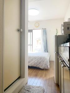 Zimmer mit einem Bett und einer Tür zur Küche in der Unterkunft Shinjuku Area/Nishi-Shinjuku Gochome subway 6 minutes walk/西新宿五丁目车站步行6分钟 211 in Tokio