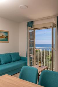 a living room with a couch and a view of the ocean at Apartments Bonazza in Petrovac na Moru