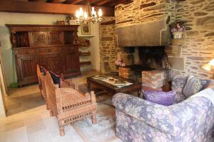 a living room with a couch and a stone fireplace at Manoir du Mur in Comblessac
