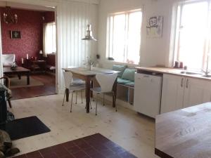 a kitchen and living room with a table and chairs at CHARMING FARM HOUSE IN GUDHJEM in Gudhjem