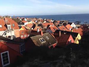 a group of houses in a city with the ocean at CHARMING FARM HOUSE IN GUDHJEM in Gudhjem