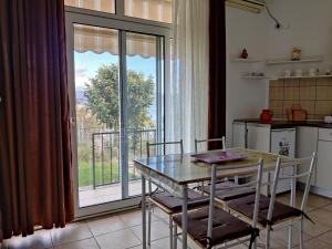 a kitchen with a table and chairs and a large window at Vila Roza in Star Dojran