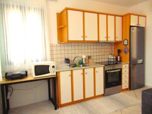 a small kitchen with a microwave and a refrigerator at Marilena Apartment, Keremies in Keramiaí