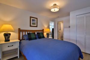 a bedroom with a blue bed and two lamps at Sandpiper Shores in Florence