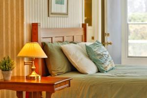 a bed with pillows and a table with a lamp at Sandpiper Shores in Florence