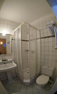 a bathroom with a shower and a toilet and a sink at Hotel La Porte de France in Bouillon