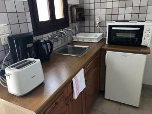 a kitchen counter with a microwave and a sink at Hotel Apartment Agios Konstantinos in Ágios Konstantínos