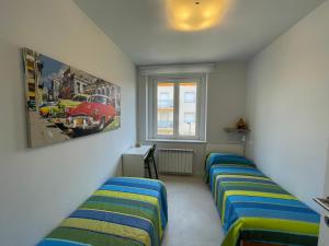 a room with two beds and a picture of a car at San Pietro D'orio Verde in Grado