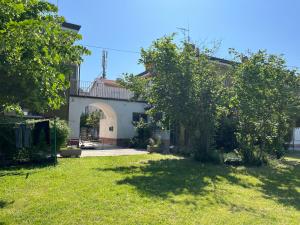 a house with a gate and a yard with trees at San Pietro D'orio Verde in Grado +4 photos