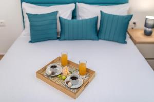 a tray of food on a bed with two glasses of orange juice at Apartments Bonazza in Petrovac na Moru