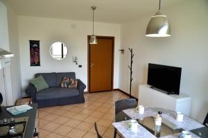 ein Wohnzimmer mit einem Sofa und einem TV in der Unterkunft Giulio Cesare Apartment close to Venice in Salzano