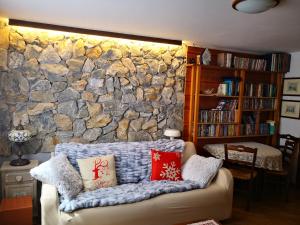 sala de estar con pared de piedra y sofá en Chalet Luna, en Caspoggio