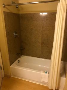 y baño con bañera y cortina de ducha. en MainStay Suites Jacksonville near Camp Lejeune, en Jacksonville