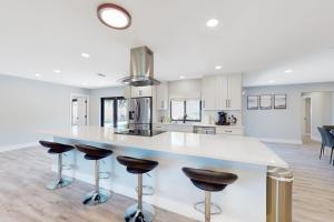 a kitchen with a white counter and bar stools at Deerfield Divine in Deerfield Beach