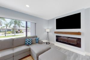 a living room with a couch and a flat screen tv at Deerfield Divine in Deerfield Beach