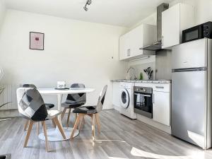 a kitchen with a table and chairs and a refrigerator at Charmant appartement avec terrasse parking in Ispagnac +18 photos