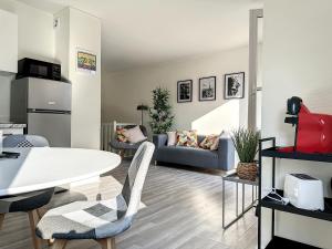 a living room with a table and a couch at Charmant appartement avec terrasse parking in Ispagnac