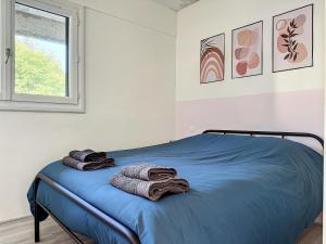 a bedroom with a bed with towels on it at Charmant appartement avec terrasse parking in Ispagnac